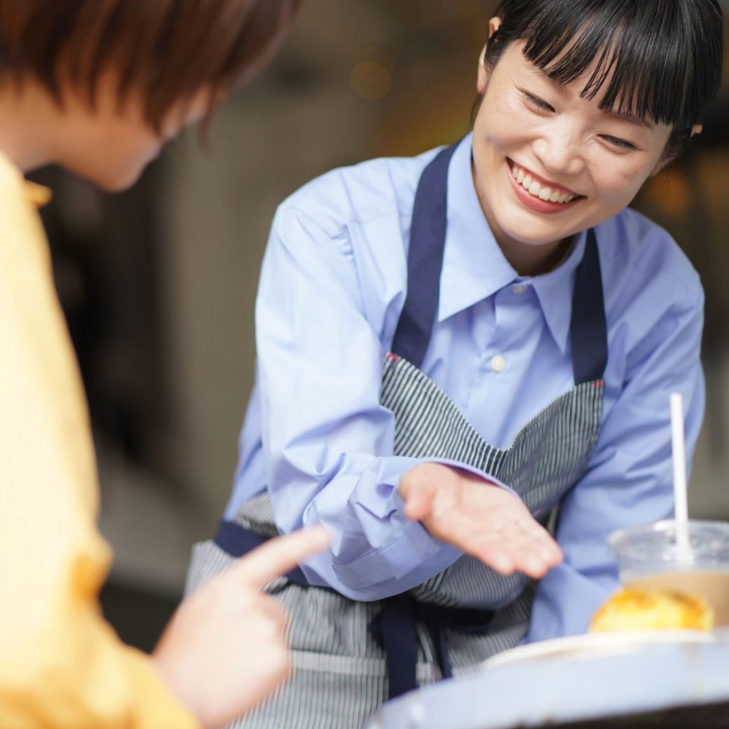 カフェの女性スタップが笑顔で接客